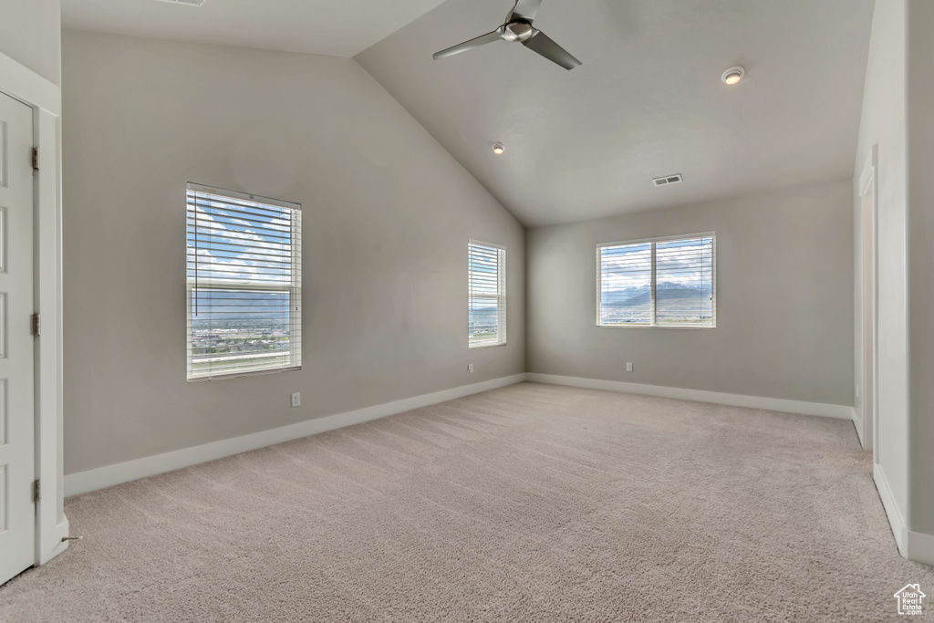 Spare room with light carpet, lofted ceiling, a ceiling fan, baseboards, and recessed lighting