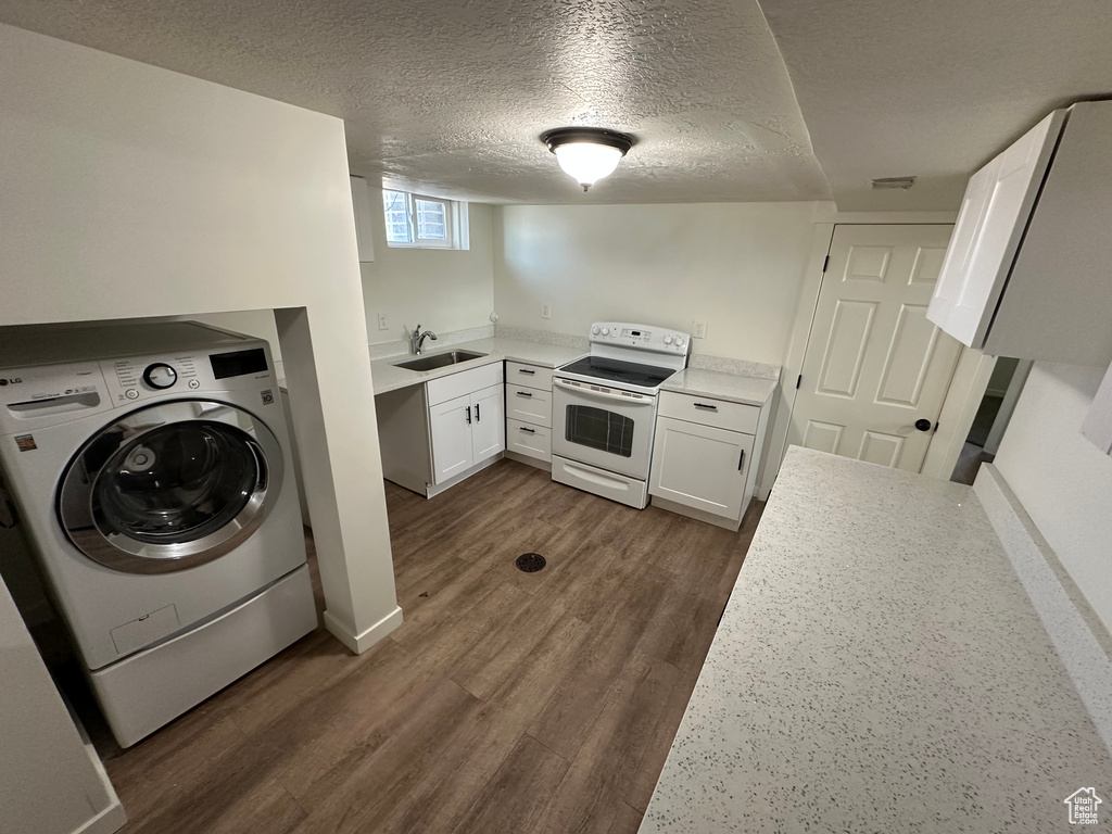 Laundry area featuring washer / clothes dryer, dark wood finished floors, a textured ceiling, and baseboards