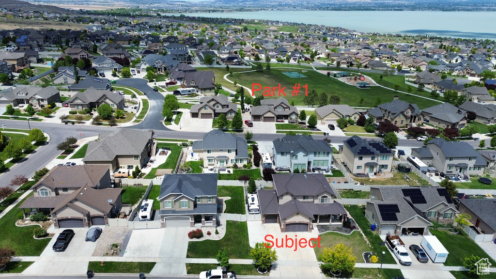 Aerial view of property and surrounding area with nearby suburban area and a large body of water
