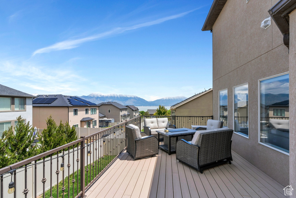 Wooden deck featuring a mountain view, an outdoor living space, and a residential view
