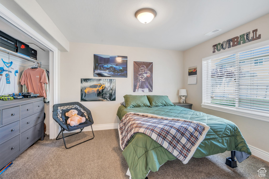 Bedroom featuring carpet and baseboards