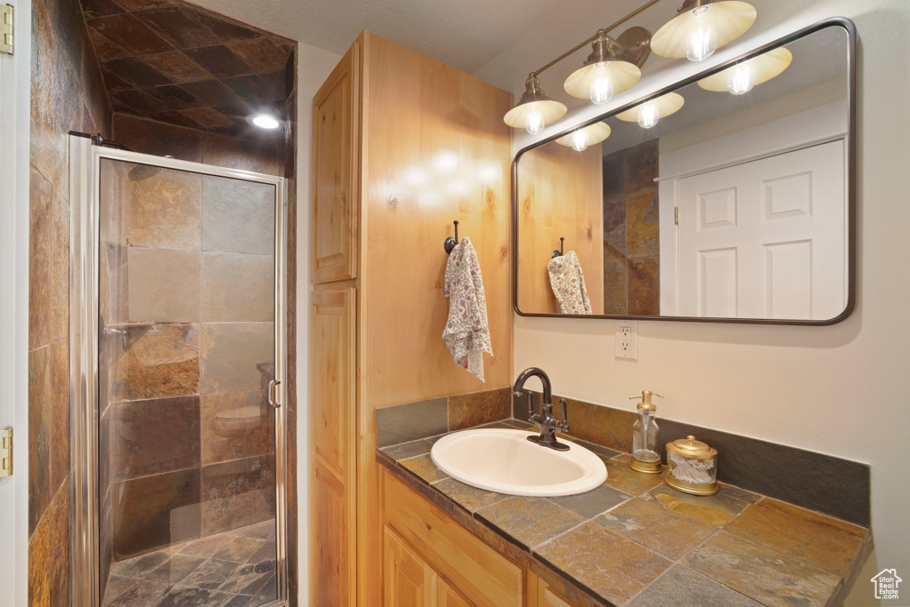 Full bath with a shower stall and vanity