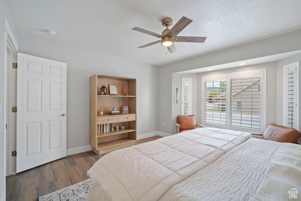 Bedroom with dark wood-style floors, baseboards, and ceiling fan
