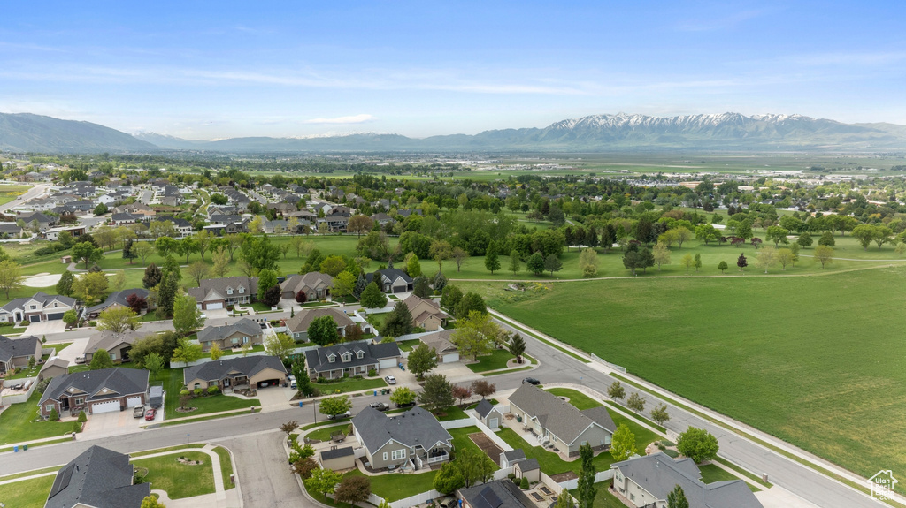 Aerial view of property and surrounding area with mountains and nearby suburban area