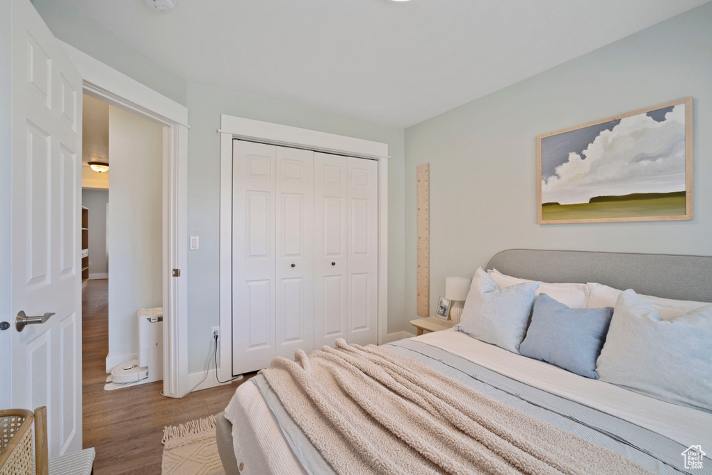 Bedroom featuring wood finished floors, a closet, and baseboards