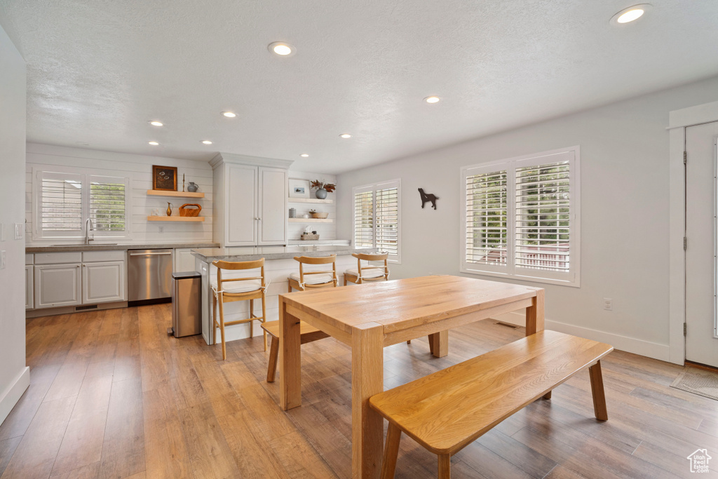 Dining space with healthy amount of natural light, recessed lighting, light wood finished floors, and baseboards