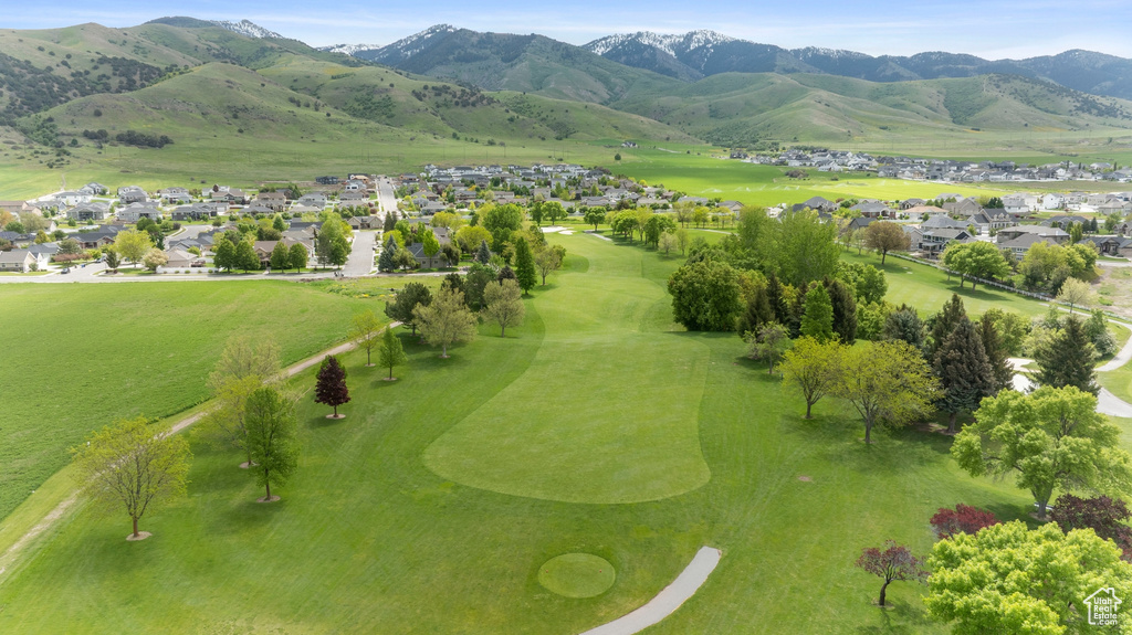 Aerial perspective of suburban area featuring a mountain backdrop and a local golf course