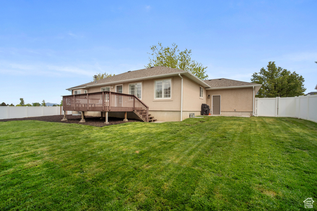 Rear view of house featuring a wooden deck and stucco siding