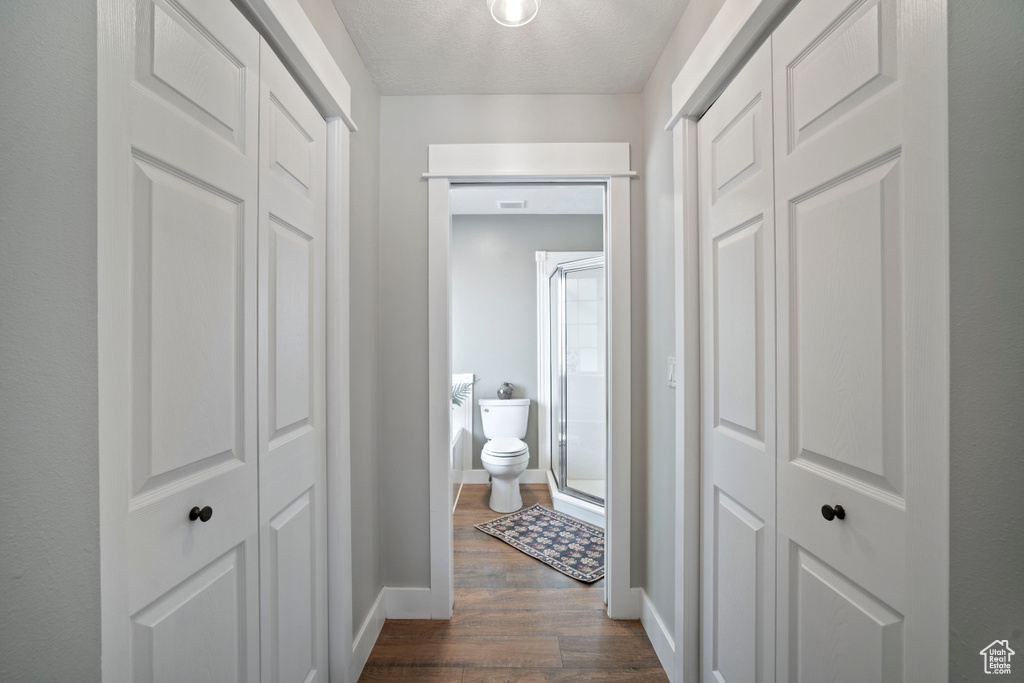 Hall with dark wood-style floors and baseboards