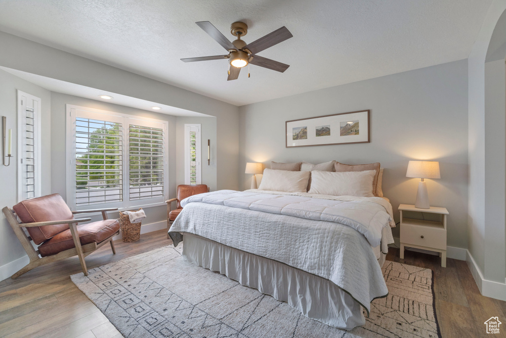 Bedroom with baseboards, wood finished floors, and a ceiling fan
