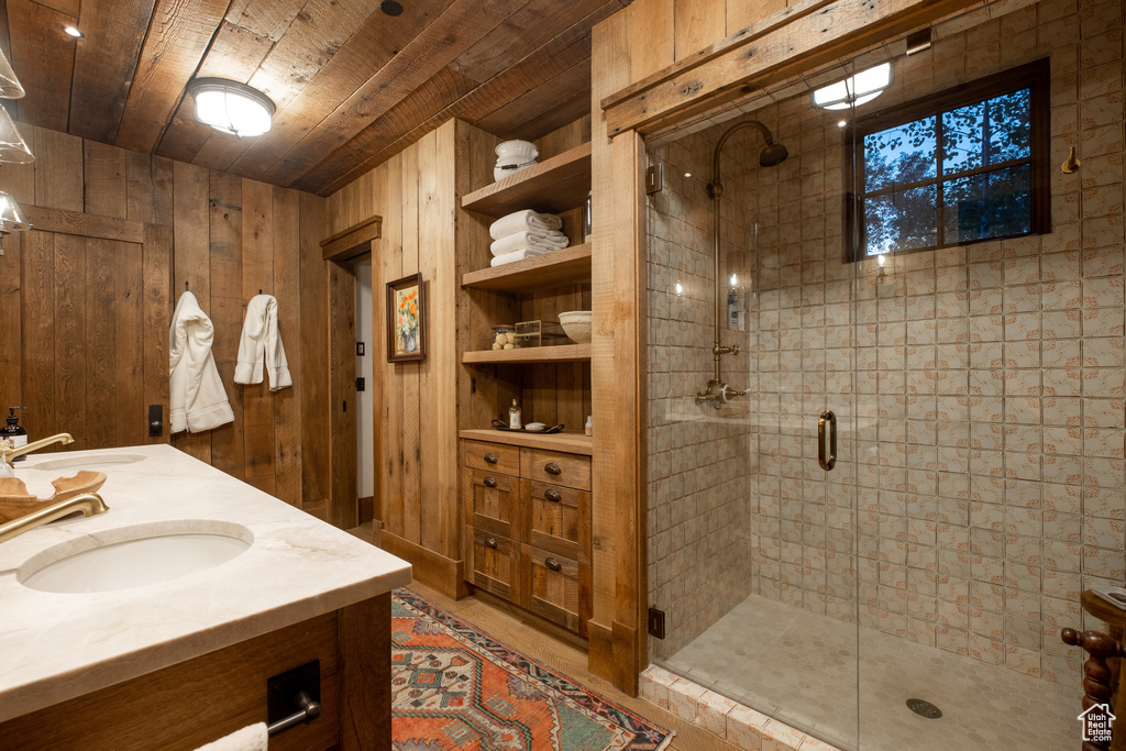 Full bath featuring a stall shower, wooden ceiling, wooden walls, and double vanity