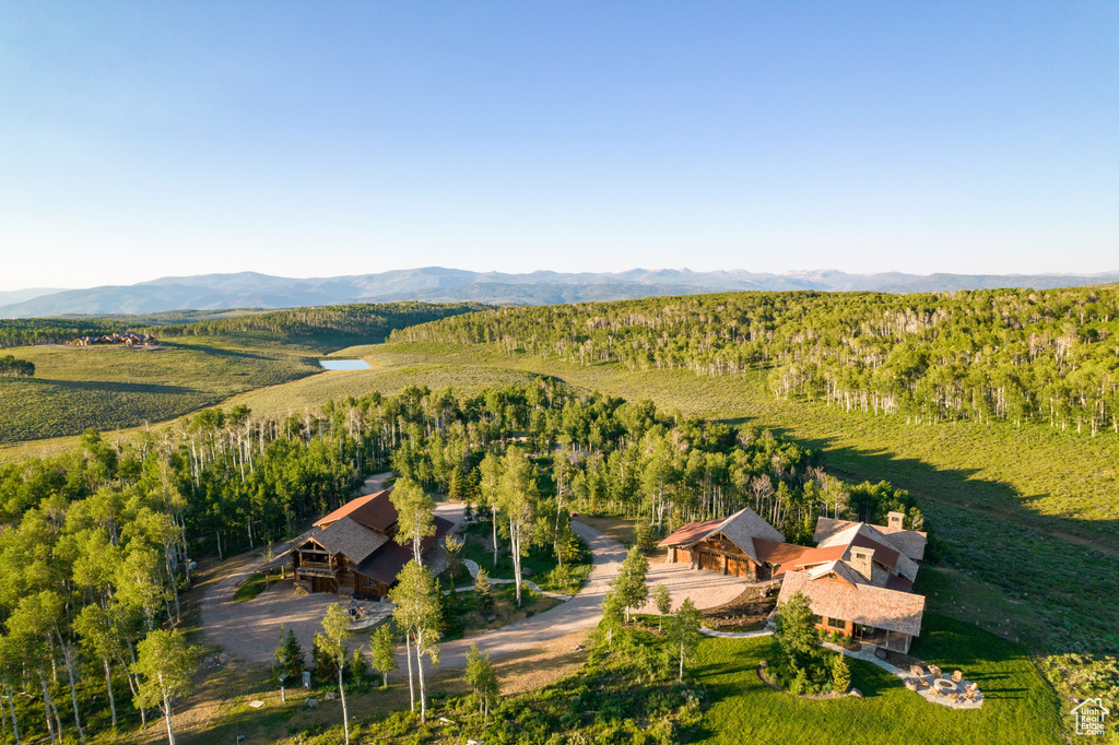 View of subject property featuring a mountainous background and a heavily wooded area