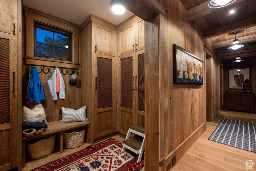 Mudroom with wooden walls, wood finished floors, and beamed ceiling
