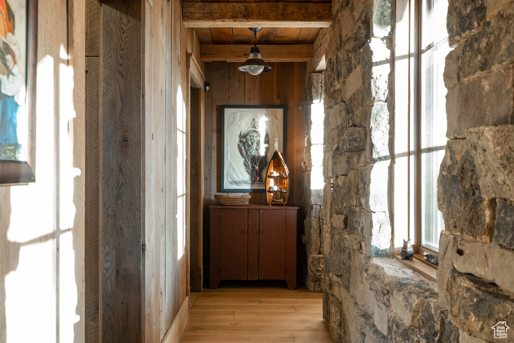Hall featuring light wood-style floors, beam ceiling, and wooden ceiling