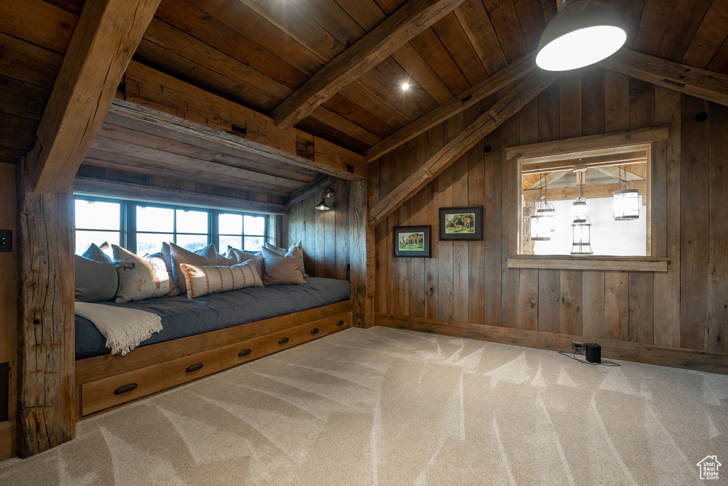 Carpeted bedroom with wooden ceiling and wooden walls