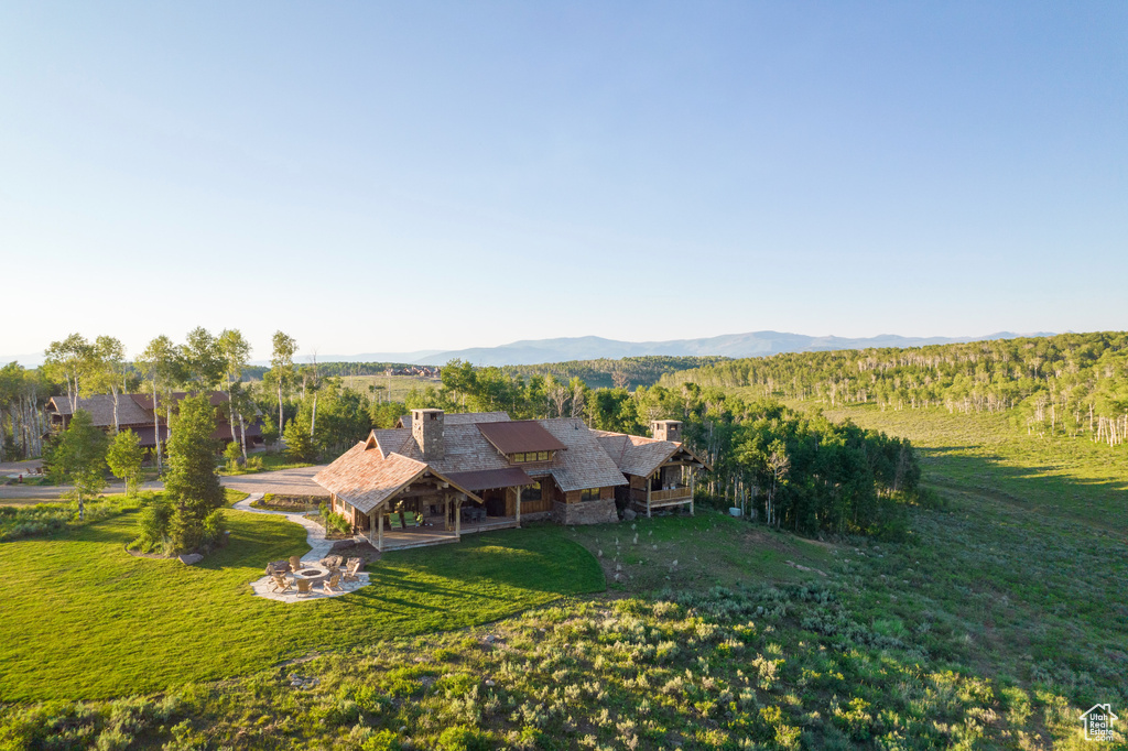 Aerial view of property and surrounding area featuring a mountainous background