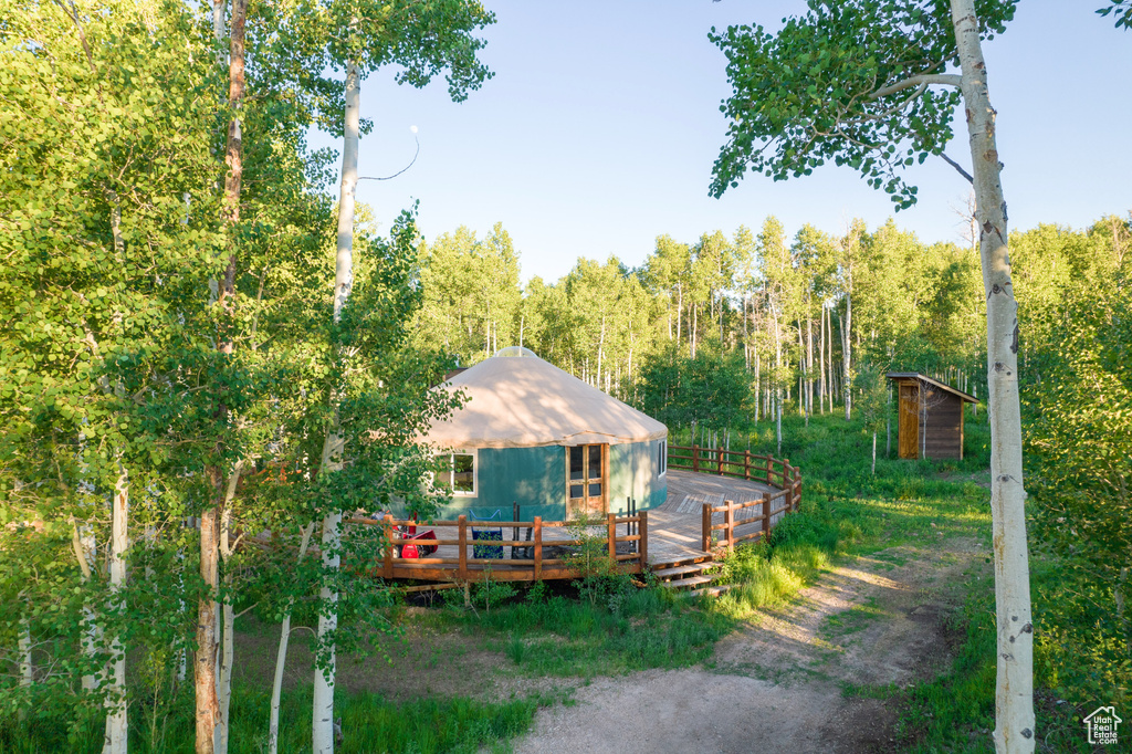 Rear view of house featuring a deck and a forest view