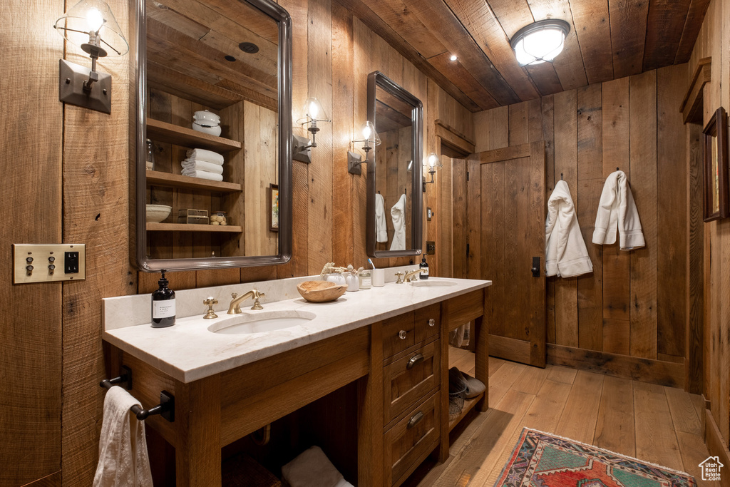 Full bathroom with wood ceiling, wooden walls, hardwood / wood-style floors, and double vanity