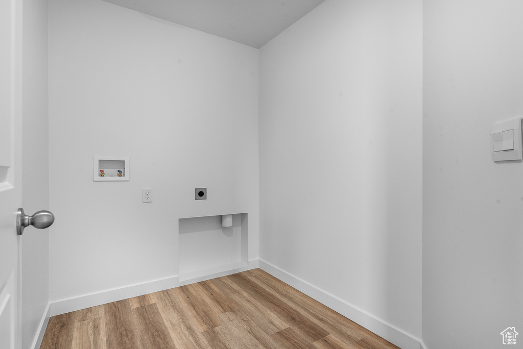 Washroom with hookup for an electric dryer, washer hookup, wood finished floors, and baseboards