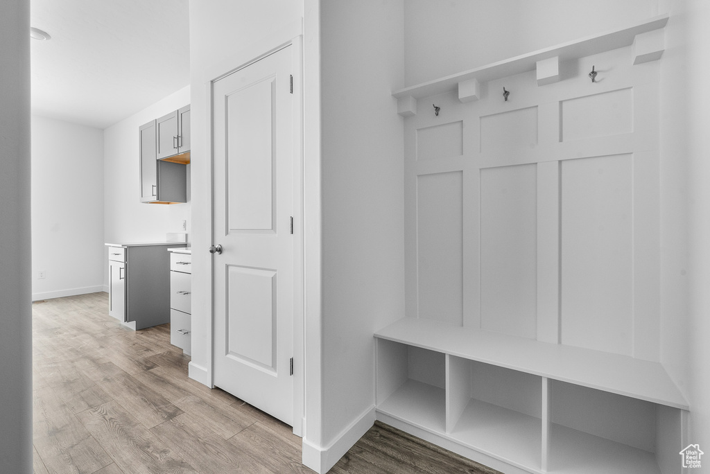 Mudroom featuring light wood finished floors and baseboards