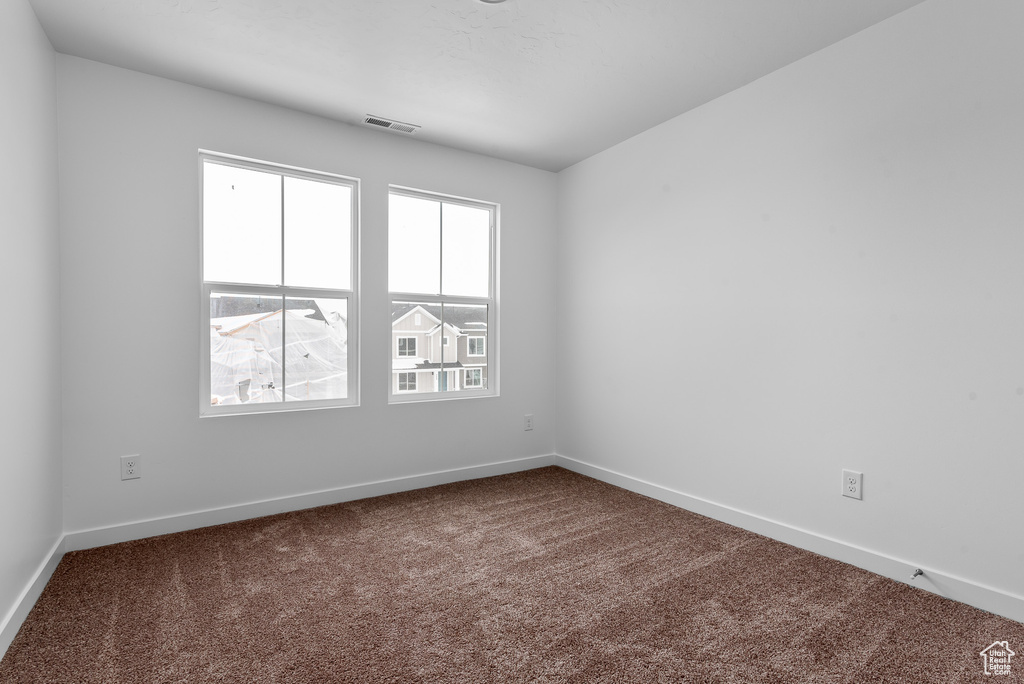 Carpeted empty room featuring healthy amount of natural light and baseboards