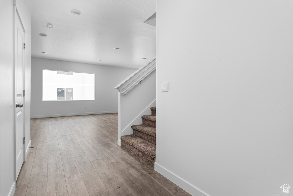 Entrance foyer featuring wood finished floors, stairway, and baseboards