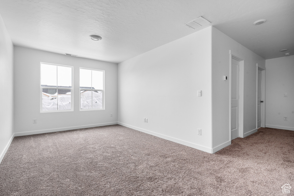 Unfurnished room featuring carpet floors and baseboards