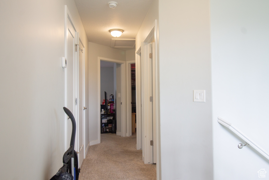 Hall featuring light carpet and baseboards