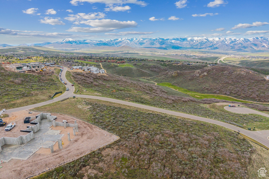 Aerial view of property and surrounding area featuring a mountainous background