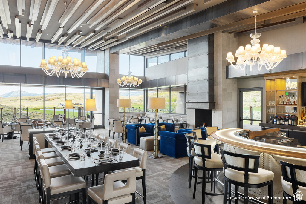 Dining area with a chandelier, a high ceiling, carpet flooring, and a mountain view