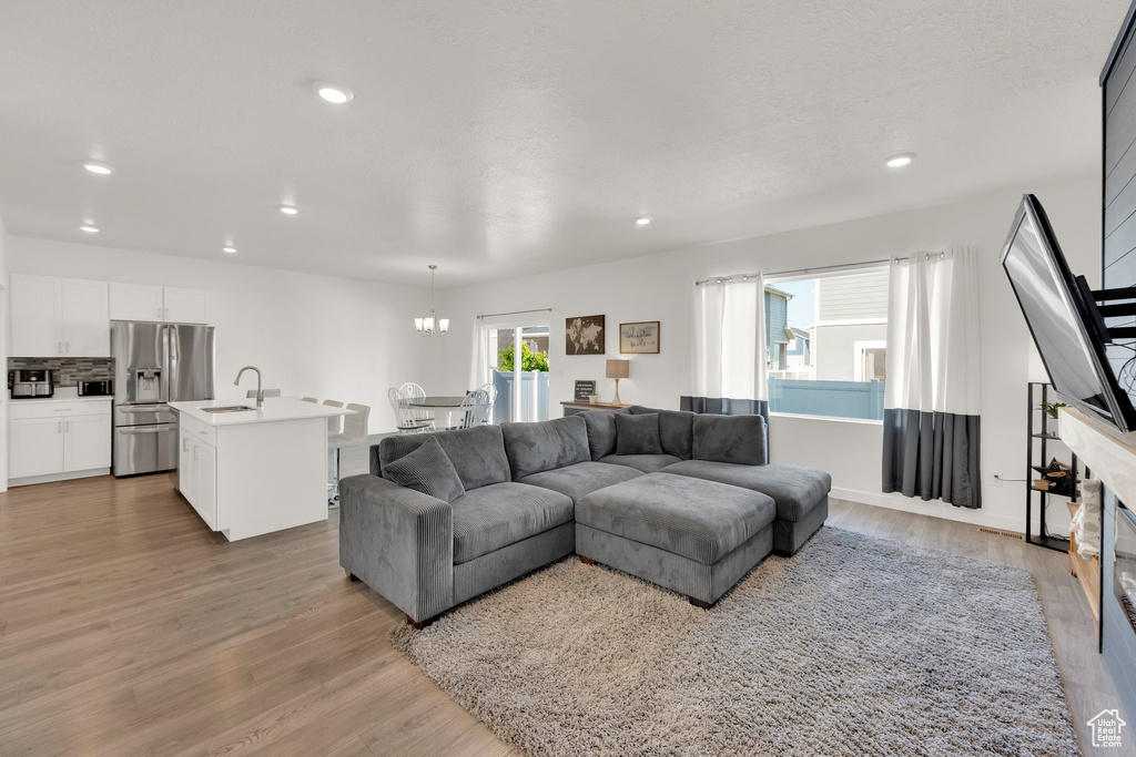 Living room featuring light wood finished floors, recessed lighting, and a chandelier