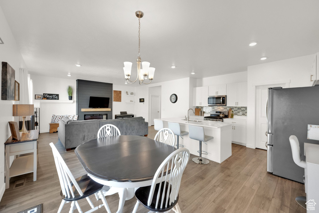 Dining area featuring recessed lighting, light wood-type flooring, and a chandelier