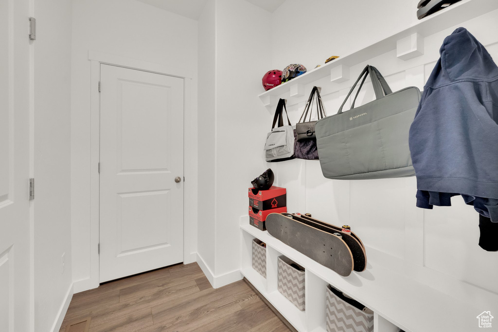 Mudroom with light wood-style floors and baseboards