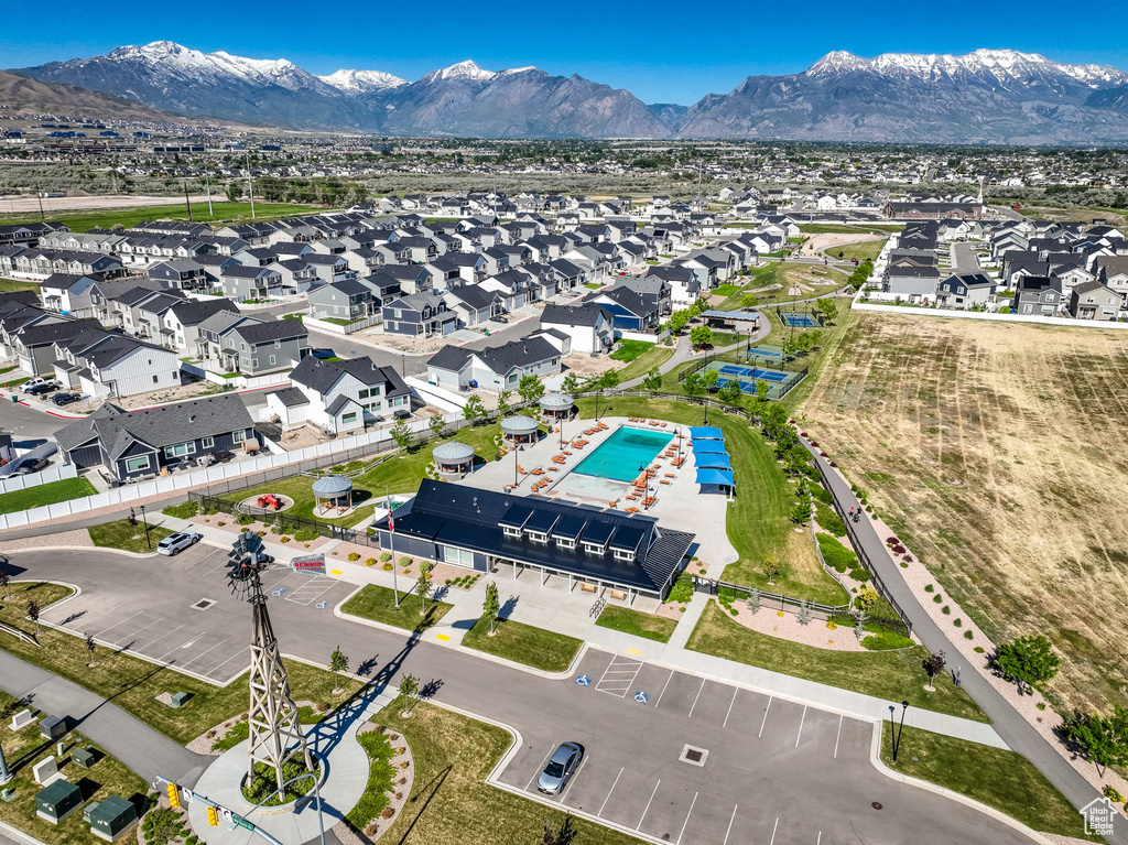 Aerial perspective of suburban area with a mountain backdrop and a pool area