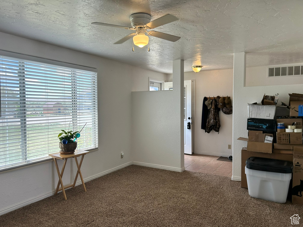 Unfurnished room with carpet flooring, ceiling fan, a textured ceiling, and baseboards