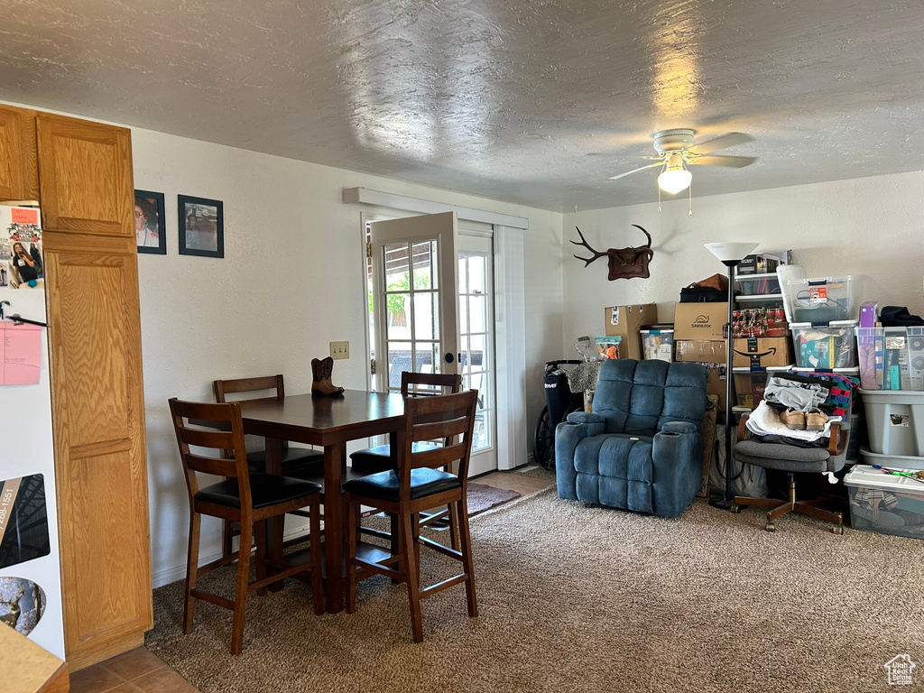 Dining space featuring a ceiling fan and a textured ceiling