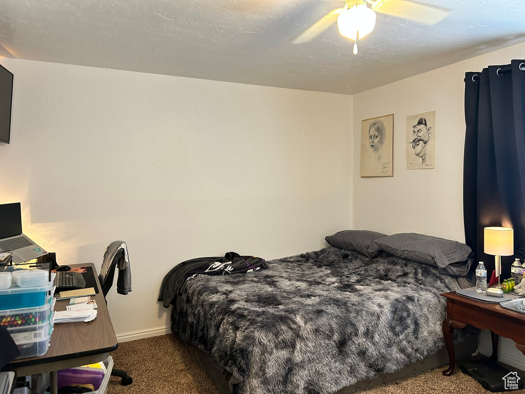 Carpeted bedroom featuring baseboards and ceiling fan