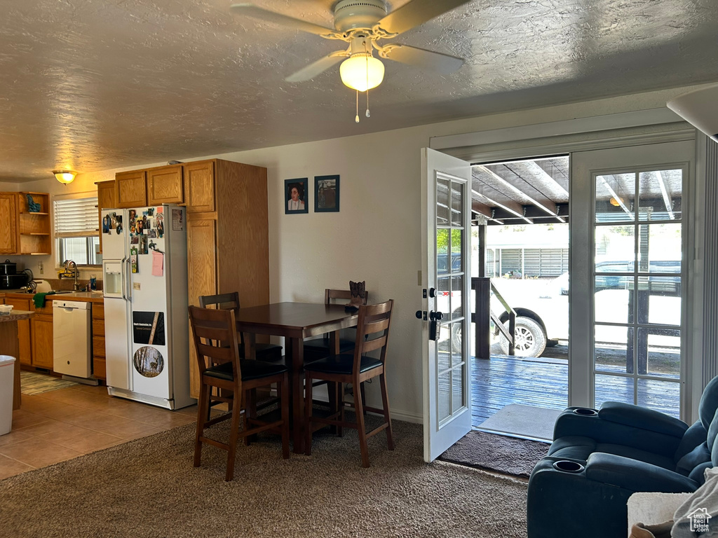 Dining space with a ceiling fan and tile patterned floors