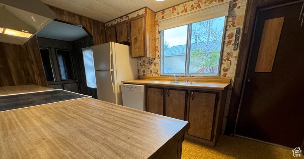 Kitchen featuring white appliances, a sink, and light countertops