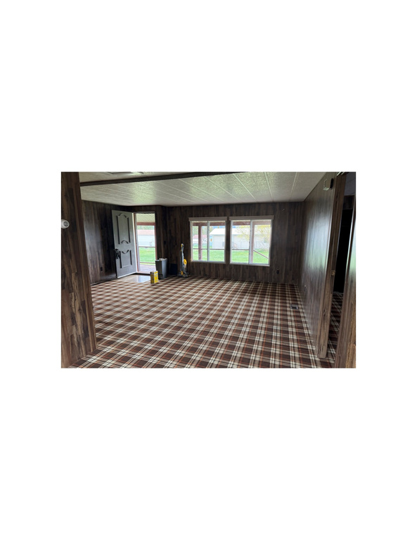 Carpeted spare room with wood walls