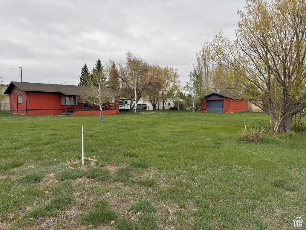 View of grassy yard with an outbuilding and a garage