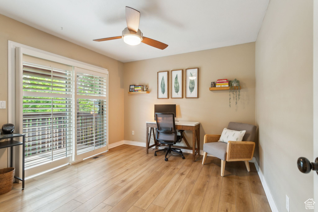 Office area featuring light wood finished floors, a ceiling fan, and baseboards