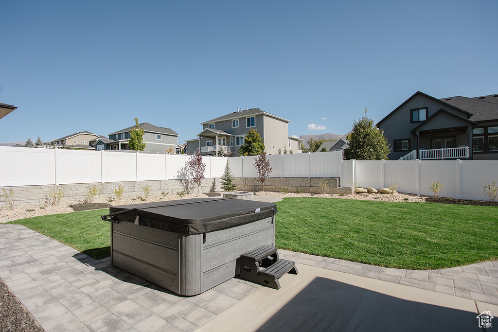 View of patio featuring a hot tub and a residential view