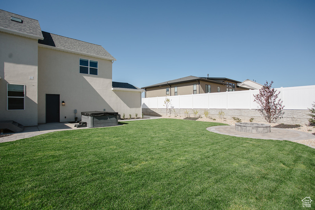 View of yard with a hot tub and a patio area