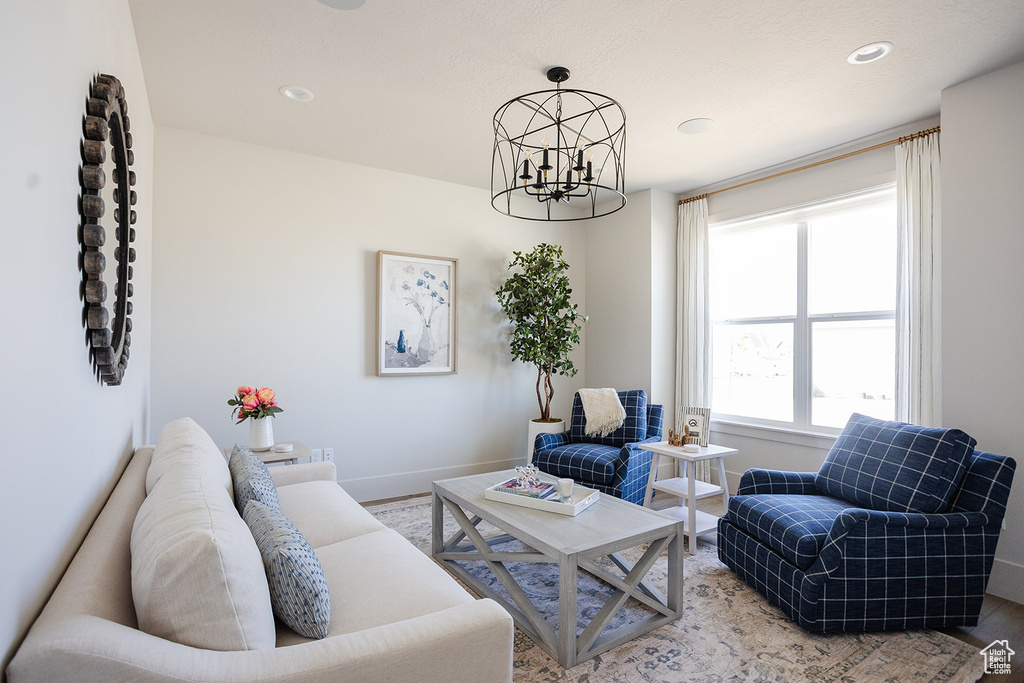 Living area with a chandelier, baseboards, wood finished floors, and recessed lighting