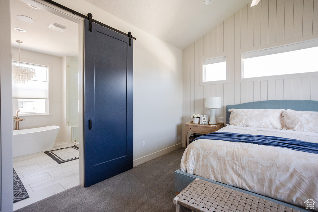 Bedroom with a barn door and lofted ceiling
