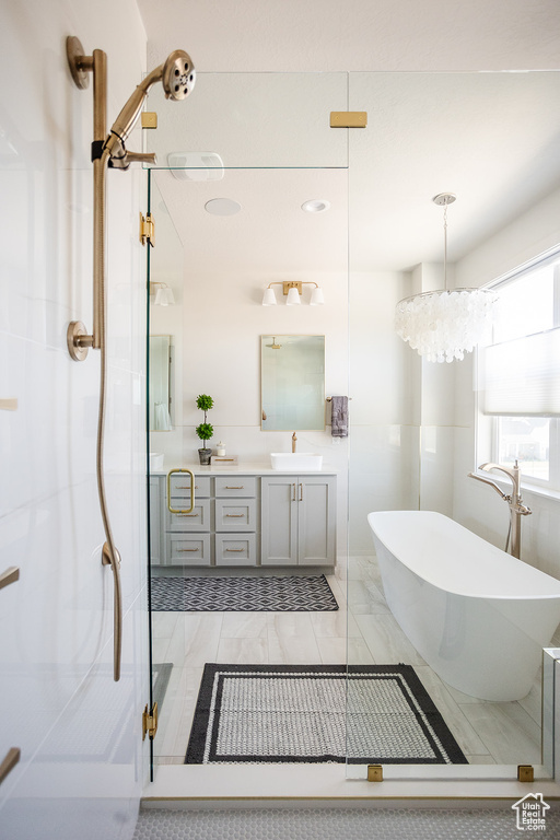 Bathroom with vanity, a freestanding bath, a stall shower, and marble finish flooring