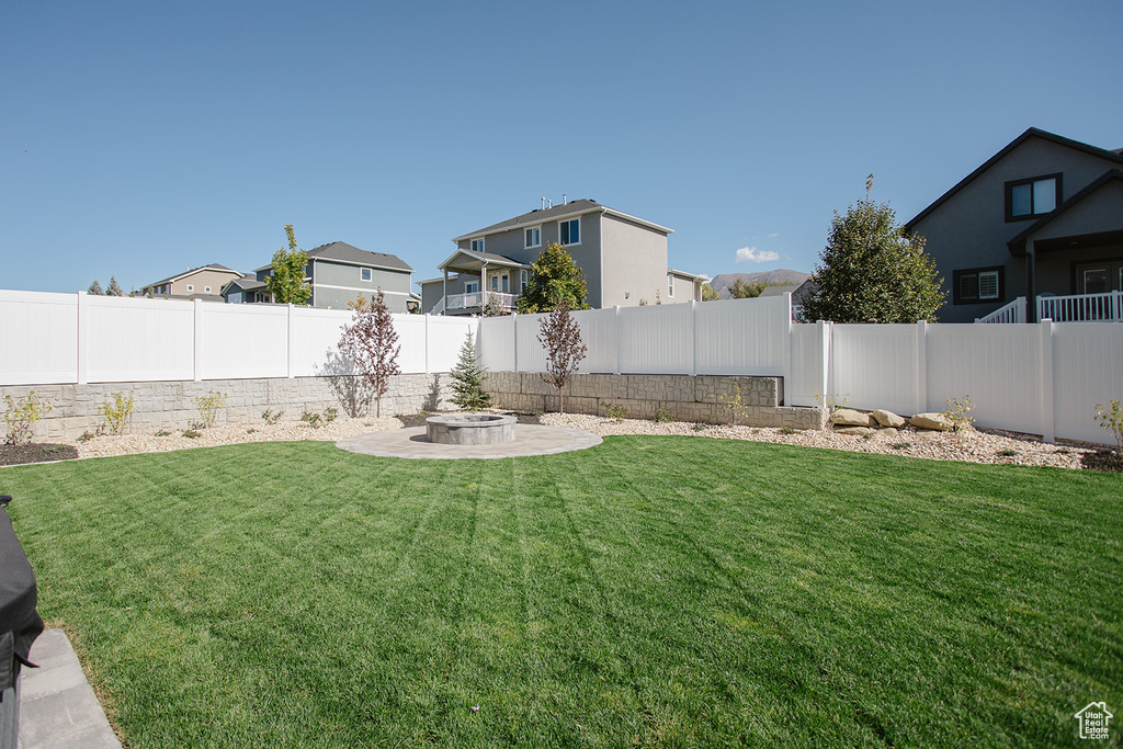 View of yard with a fire pit, a residential view, and a patio