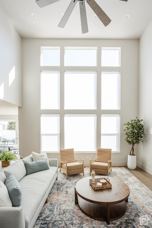 Living area featuring ceiling fan, wood finished floors, baseboards, and recessed lighting