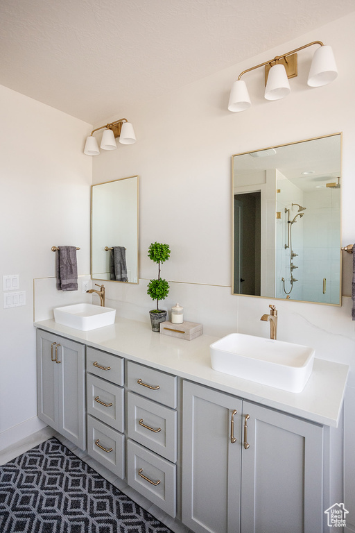 Full bathroom with double vanity and a shower stall